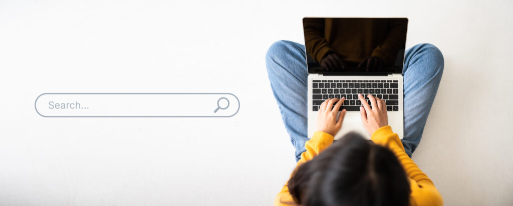Top view of a women using a computer laptop to find what they are interested in.